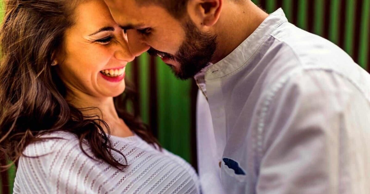 Close-up of a happy couple laughing and embracing outdoors in Toledo, Spain.
