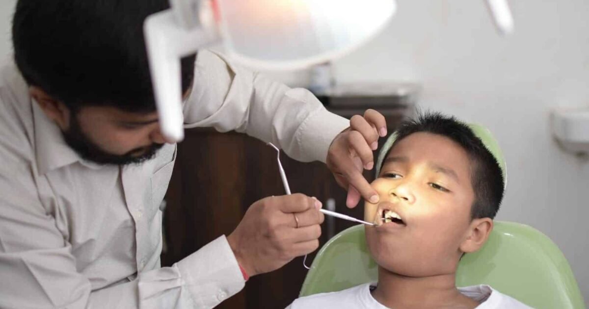 A dentist checks a child's teeth in a well-lit dental clinic, focusing on oral care.