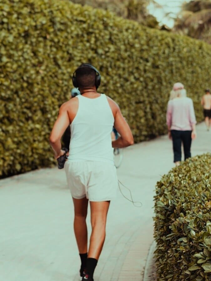 woman in white tank top and white shorts holding black dslr camera