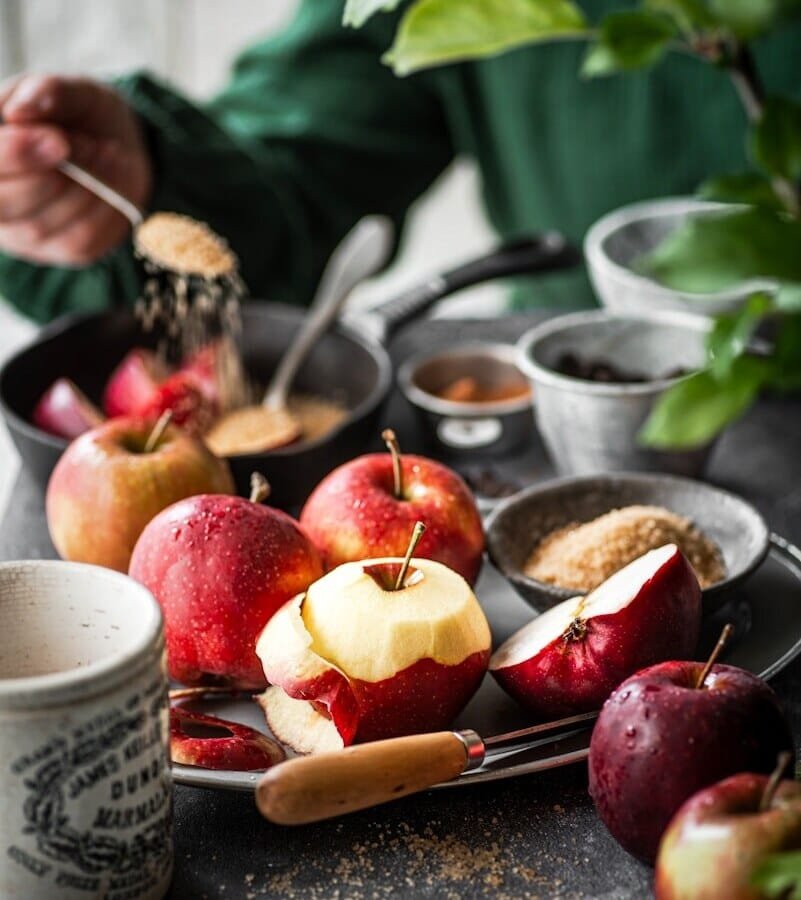 a table topped with plates of apples and a cup of coffee