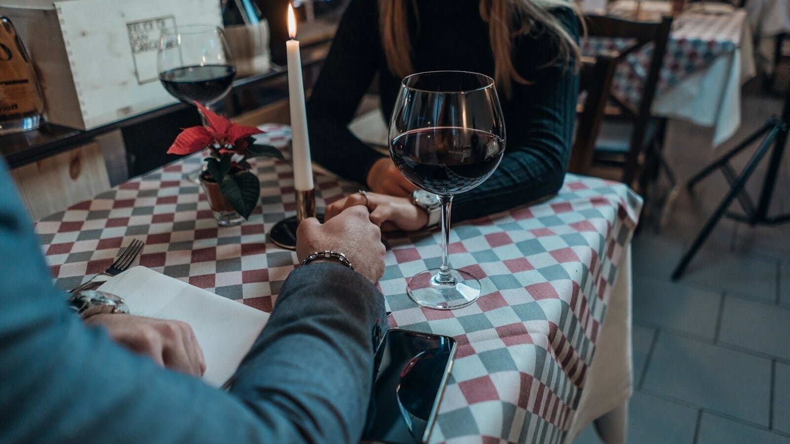 woman wearing black sweater holding hand with man wearing gray suit jacket