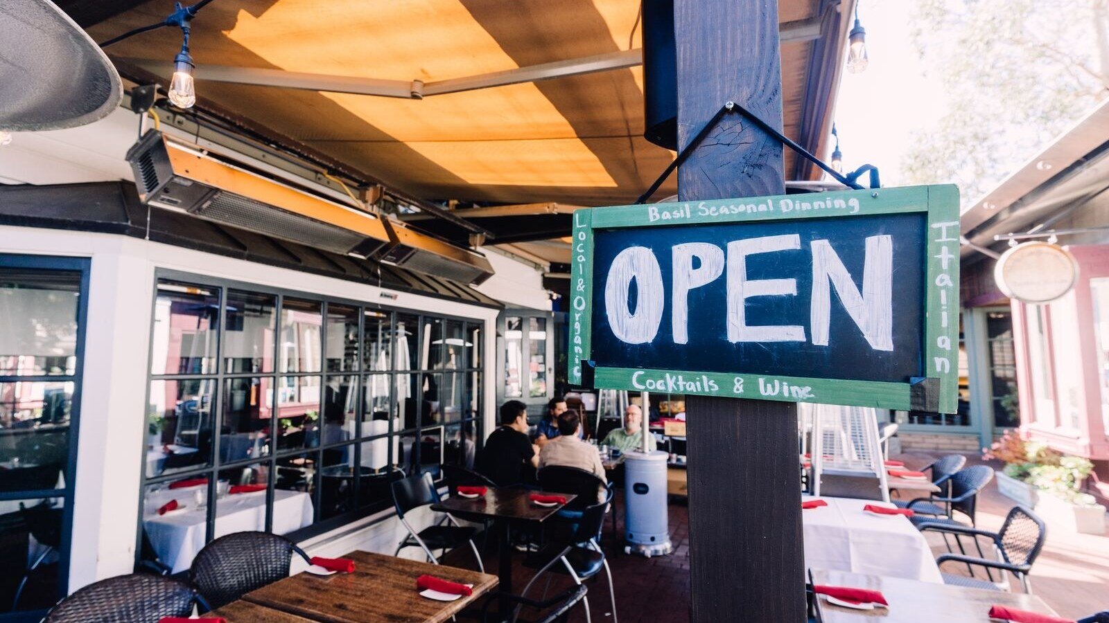 Charming outdoor café with open sign, patio seating, and inviting ambiance.