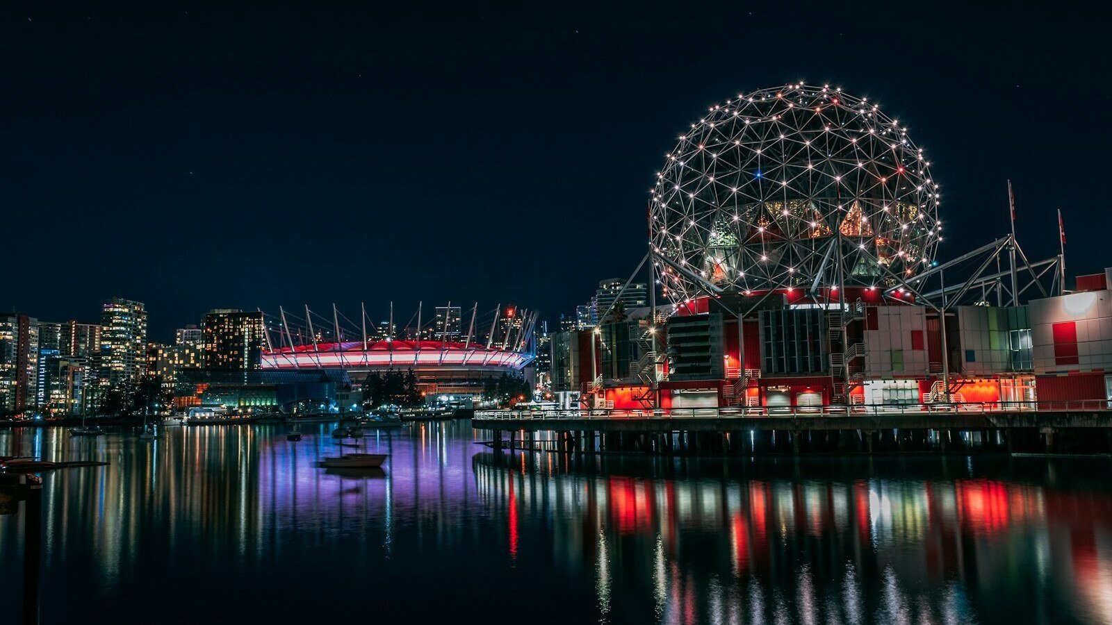 skyline photography of boat passing on waters overlooking buildings