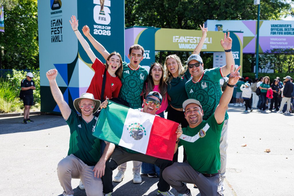 Group of international fans posing with Mexican flag at FIFA Fan Festival Vancouver entrance