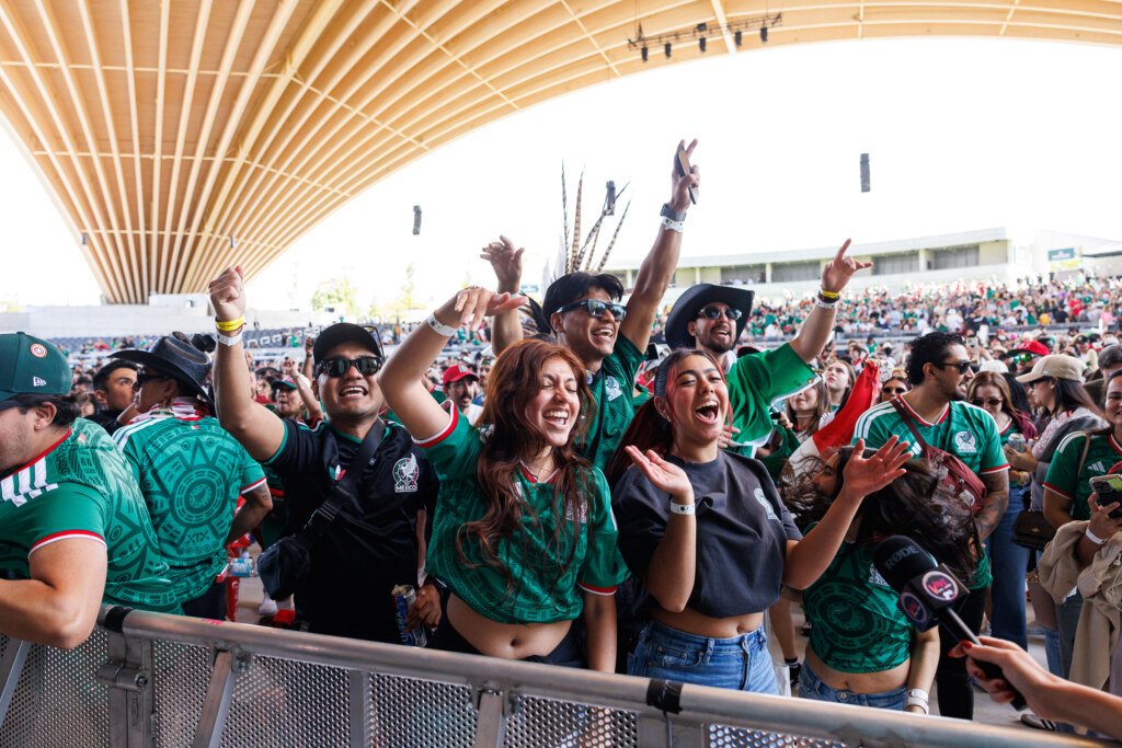 Excited Mexican fans cheering with hands raised at FIFA Fan Festival Vancouver
