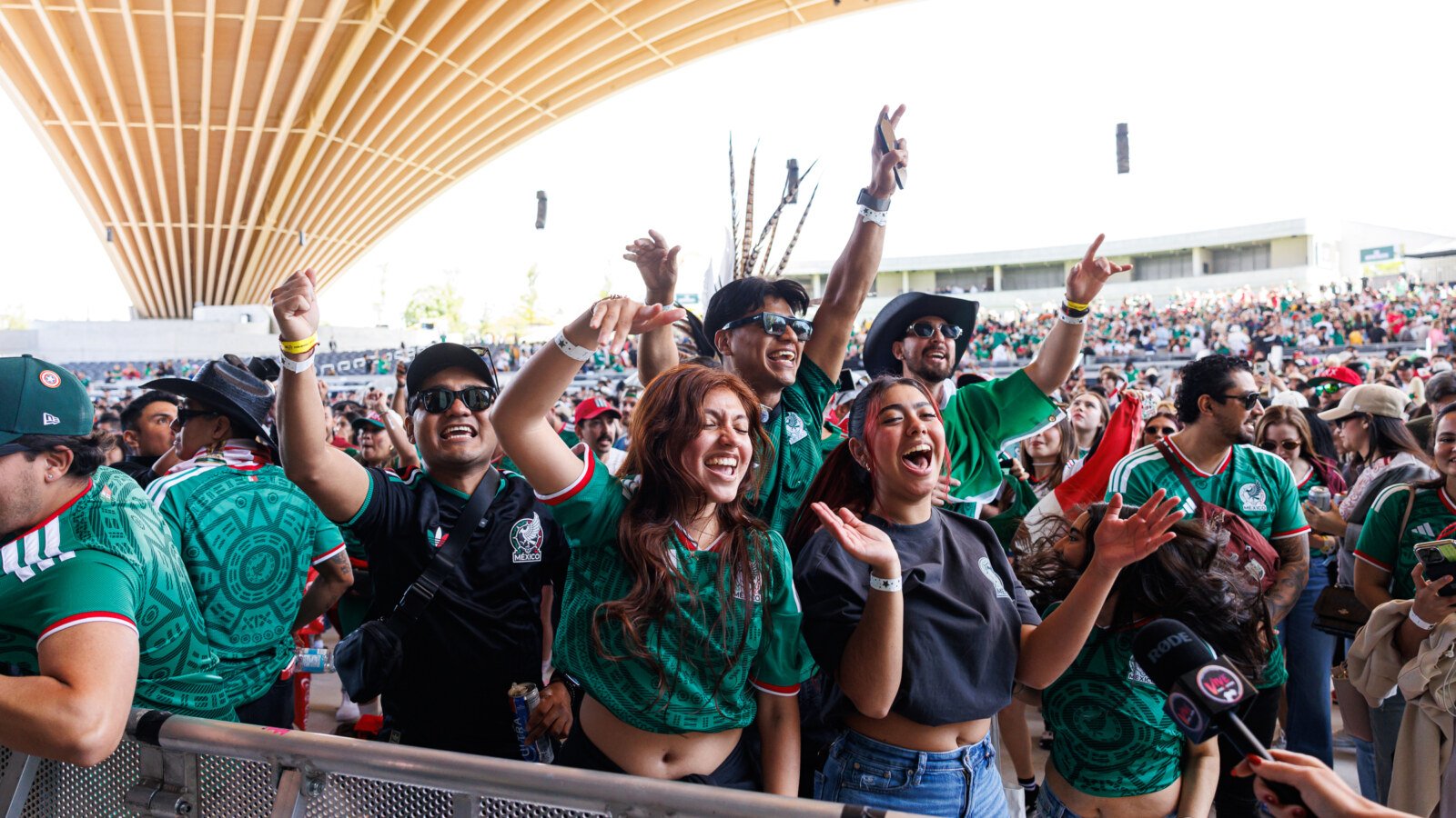 Excited Mexican fans cheering with hands raised at FIFA Fan Festival Vancouver