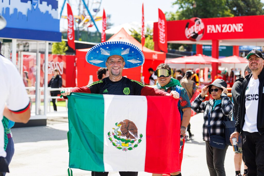 Fan in sombrero holding Mexican flag at Coca-Cola Fan Zone FIFA Fan Festival Vancouver