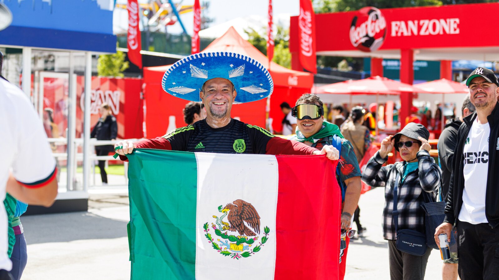 Fan in sombrero holding Mexican flag at Coca-Cola Fan Zone FIFA Fan Festival Vancouver