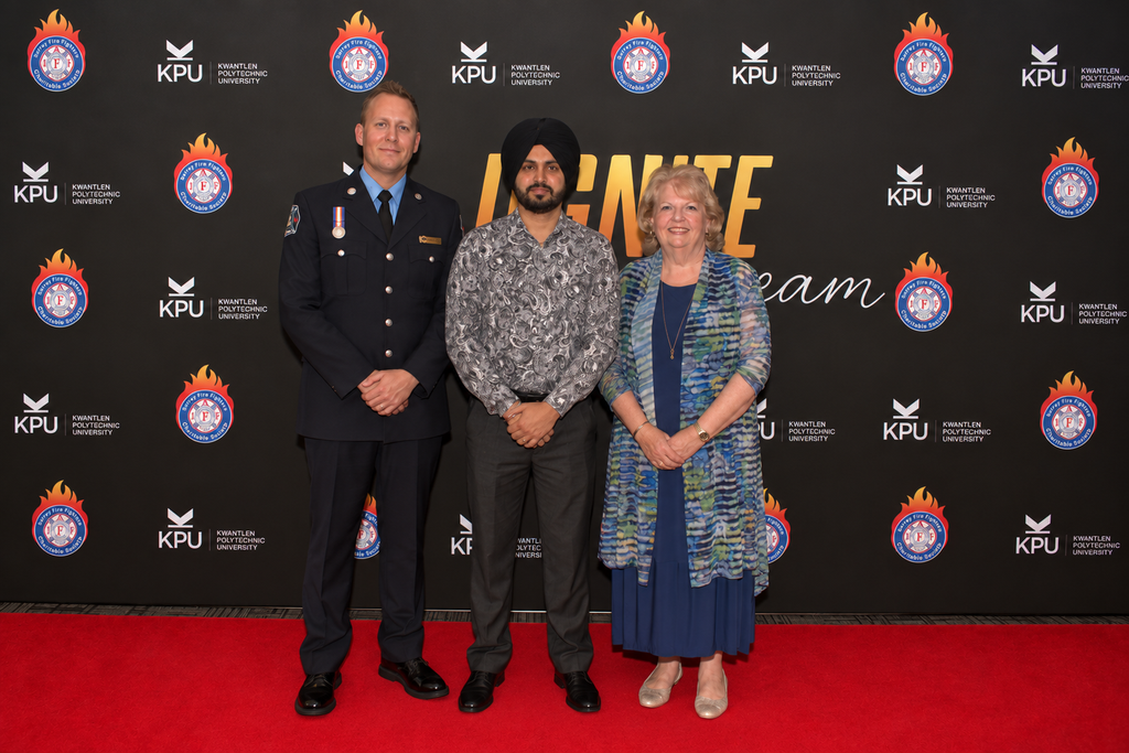 Three people posing at an event.